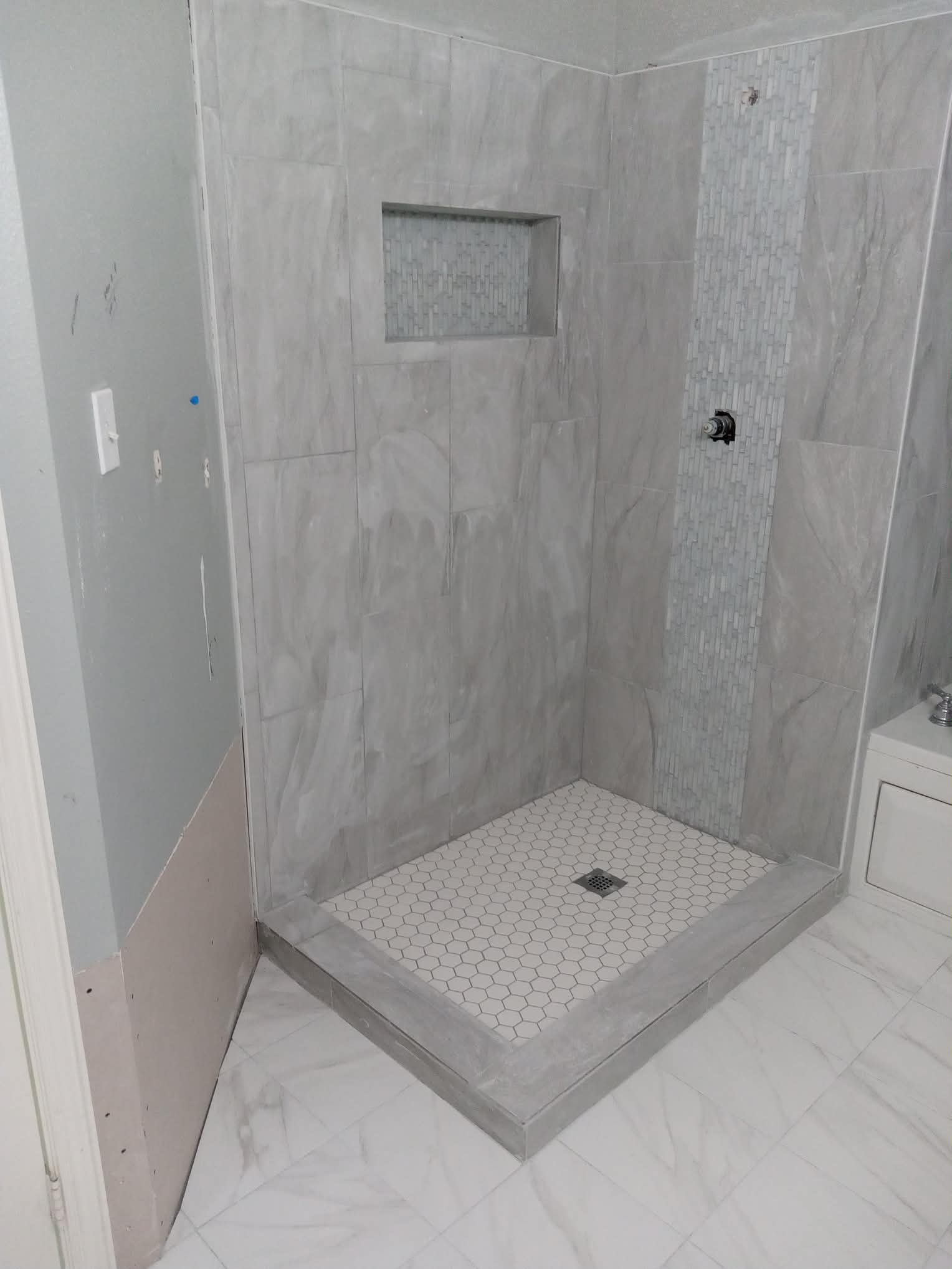 Gray marble tile shower with hexagon floor