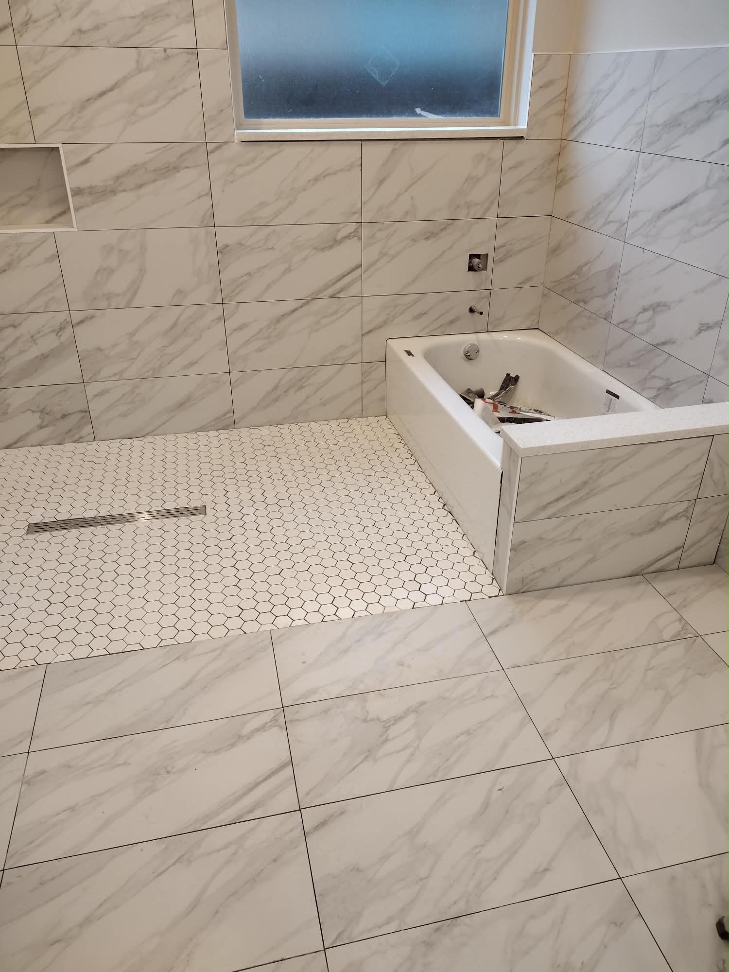 Marble bathroom with bathtub and hexagon tile shower